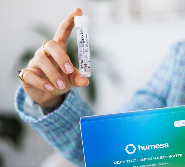 Людина тримає флакон ДНК-тесту Humess